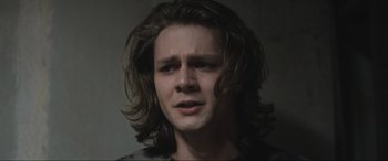 Movie still from “Insidious: The Red Door” (2023), directed by Patrick Wilson – A man with long hair and a sad look on his face; Close Up shot, Over the shoulder angle