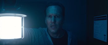 Movie still from “Insidious: The Red Door” (2023), directed by Patrick Wilson – A person taking a selfie in the dark; Close Up shot, Overhead angle
