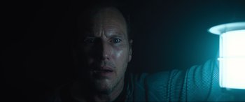 Movie still from “Insidious: The Red Door” (2023), directed by Patrick Wilson – A person looking at the camera; Close Up shot, Low angle
