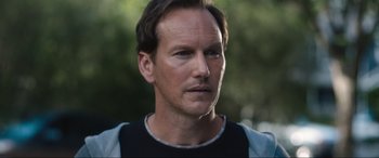 Movie still from “Insidious: The Red Door” (2023), directed by Patrick Wilson – A person wearing a black and white shirt; Close Up shot, Over the shoulder angle