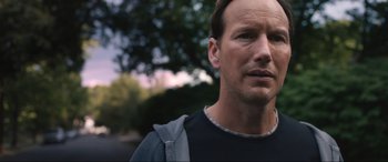 Movie still from “Insidious: The Red Door” (2023), directed by Patrick Wilson – A person wearing a black shirt; Close Up shot, Over the shoulder angle