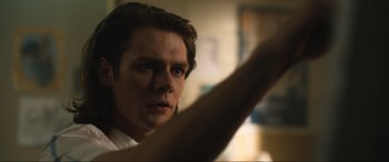 Movie still from “Insidious: The Red Door” (2023), directed by Patrick Wilson – A young man is holding his arm up in the dark; Close Up shot, Low angle