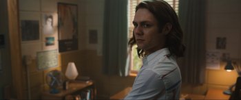 Movie still from “Insidious: The Red Door” (2023), directed by Patrick Wilson – A man with long brown hair wearing a white shirt; Medium shot, Over the shoulder angle