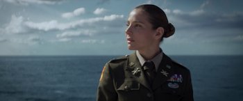 Movie still from “Interceptor” (2022), directed by Matthew Reilly – A woman in a military uniform looking out at the ocean; Close Up shot, Low angle