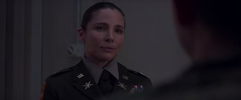 Movie still from “Interceptor” (2022), directed by Matthew Reilly – A woman in a military uniform is looking at the camera; Close Up shot, Over the shoulder angle