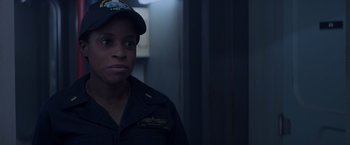 Movie still from “Interceptor” (2022), directed by Matthew Reilly – A woman in a navy uniform is looking at the camera; Close Up shot, Over the shoulder angle