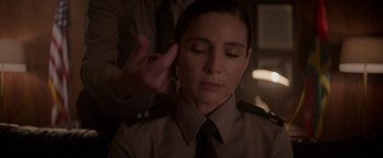 Movie still from “Interceptor” (2022), directed by Matthew Reilly – A woman in a police uniform putting her hand to her ear; Close Up shot, Over the shoulder angle