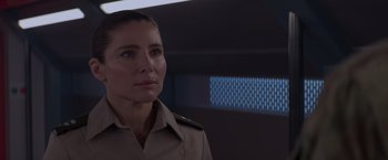 Movie still from “Interceptor” (2022), directed by Matthew Reilly – A woman wearing a uniform looking to her left; Close Up shot, Over the shoulder angle