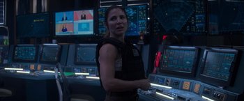 Movie still from “Interceptor” (2022), directed by Matthew Reilly – A woman standing in front of a control room; Medium shot, Over the shoulder angle