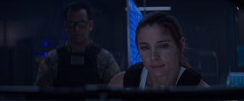 Movie still from “Interceptor” (2022), directed by Matthew Reilly – A woman with a bandage on her head looking at a computer screen; Close Up shot, Over the shoulder angle