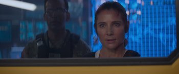 Movie still from “Interceptor” (2022), directed by Matthew Reilly – A woman looking out of a window in a room; Close Up shot, Over the shoulder angle