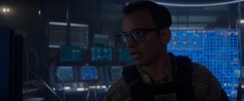 Movie still from “Interceptor” (2022), directed by Matthew Reilly – A man wearing glasses and a camouflage uniform; Close Up shot, Over the shoulder angle