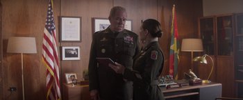 Movie still from “Interceptor” (2022), directed by Matthew Reilly – A man and a woman in military uniforms looking at something on a tablet; Medium shot, Low angle