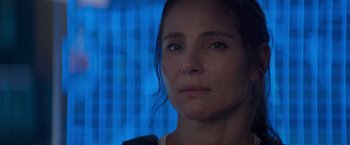 Movie still from “Interceptor” (2022), directed by Matthew Reilly – A woman's face in front of a blue background; Close Up shot, Low angle
