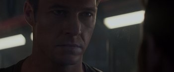 Movie still from “Interceptor” (2022), directed by Matthew Reilly – A man's face in a dark room; Close Up shot, Low angle