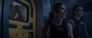 Movie still from “Interceptor” (2022), directed by Matthew Reilly – A woman standing in front of a wall; Close Up shot, Over the shoulder angle