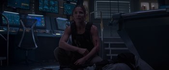 Movie still from “Interceptor” (2022), directed by Matthew Reilly – A woman in a black tank top holding a gun; Medium shot, Low angle