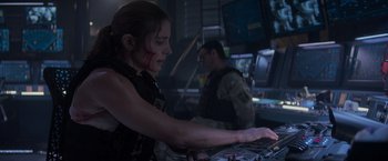 Movie still from “Interceptor” (2022), directed by Matthew Reilly – A woman in a black shirt and a man in a black jacket; Medium shot, Over the shoulder angle