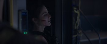 Movie still from “Interceptor” (2022), directed by Matthew Reilly – A woman with blood on her face looking out of a window; Close Up shot, Over the shoulder angle