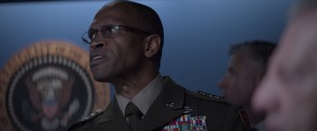 Movie still from “Interceptor” (2022), directed by Matthew Reilly – A person wearing a military uniform; Close Up shot, Over the shoulder angle