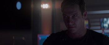 Movie still from “Interceptor” (2022), directed by Matthew Reilly – A person in a dark room; Close Up shot, Over the shoulder angle