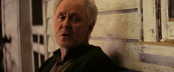 Movie still from “Interstellar” (2014), directed by Christopher Nolan – An older man with white hair looking at the camera; Close Up shot, Low angle