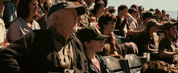 Movie still from “Interstellar” (2014), directed by Christopher Nolan – An older man and a young boy are watching a baseball game; Medium shot, Over the shoulder angle