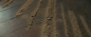 A coin sitting on top of a dirt surface