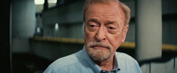 Movie still from “Interstellar” (2014), directed by Christopher Nolan – An older man with a beard and mustache; Close Up shot, Low angle