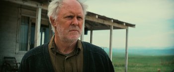 Movie still from “Interstellar” (2014), directed by Christopher Nolan – An older man with white hair and a brown shirt; Close Up shot, Low angle