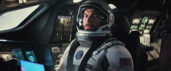 Movie still from “Interstellar” (2014), directed by Christopher Nolan – A man in a spacesuit is in the cockpit of an airplane; Medium shot, Low angle