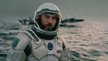 Movie still from “Interstellar” (2014), directed by Christopher Nolan – A man in a spacesuit standing in front of an ocean; Close Up shot, Low angle