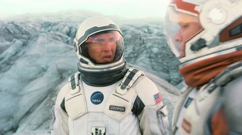 Movie still from “Interstellar” (2014), directed by Christopher Nolan – Two men in space suits standing next to each other; Medium shot, Over the shoulder angle