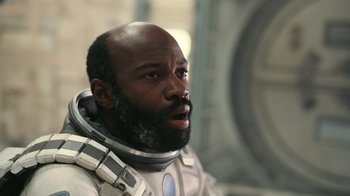 Movie still from “Interstellar” (2014), directed by Christopher Nolan – A man in a space suit looking to his left; Close Up shot, Low angle