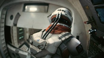 Movie still from “Interstellar” (2014), directed by Christopher Nolan – A man in a space suit is standing in front of a window; Wide shot, Low angle