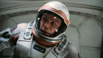 Movie still from “Interstellar” (2014), directed by Christopher Nolan – A man wearing a space suit and a helmet; Close Up shot, Overhead angle