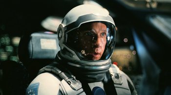 Movie still from “Interstellar” (2014), directed by Christopher Nolan – A man in a spacesuit and helmet looking into the distance; Close Up shot, Overhead angle