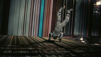 Movie still from “Interstellar” (2014), directed by Christopher Nolan – A man doing a handstand on a wooden floor; Wide shot, Overhead angle
