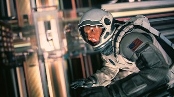 Movie still from “Interstellar” (2014), directed by Christopher Nolan – A man in a spacesuit and a helmet; Medium shot, Overhead angle
