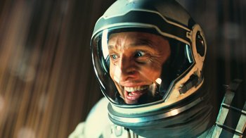 Movie still from “Interstellar” (2014), directed by Christopher Nolan – A man in a space suit is smiling for the camera; Close Up shot, Overhead angle