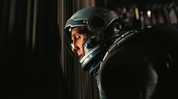 Movie still from “Interstellar” (2014), directed by Christopher Nolan – A man in a space suit looking out a window; Close Up shot, Overhead angle