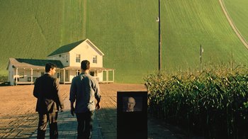 Movie still from “Interstellar” (2014), directed by Christopher Nolan – A man and two women walking in front of a house; Extreme Wide shot, Over the shoulder angle