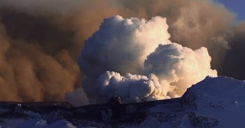 Movie still from “Into the Inferno” (2016), directed by Werner Herzog – A large cloud of smoke is coming out of the sky; Extreme Wide shot, Low angle