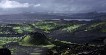 Movie still from “Into the Inferno” (2016), directed by Werner Herzog – A view of a valley with a lake in the background; Extreme Wide shot, High angle