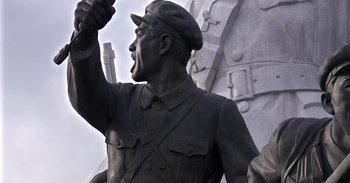 Movie still from “Into the Inferno” (2016), directed by Werner Herzog – A statue of a man with a hat on; Extreme Close Up shot, Low angle