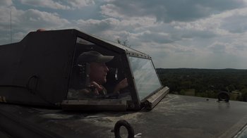 Movie still from “Into the Storm” (2014), directed by Steven Quale – A man sitting in the back of a truck; Medium shot, Low angle