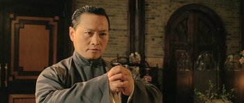 An asian man in traditional clothing holding a sword