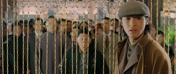 Movie still from “Ip Man” (2008), directed by Wilson Yip – A group of people standing in front of a wall of beads; Medium shot, Over the shoulder angle
