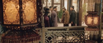 Movie still from “Ip Man” (2008), directed by Wilson Yip – A group of people standing around a building; Wide shot, Over the shoulder angle
