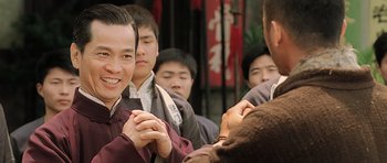 Movie still from “Ip Man” (2008), directed by Wilson Yip – A group of people standing around each other; Close Up shot, Over the shoulder angle